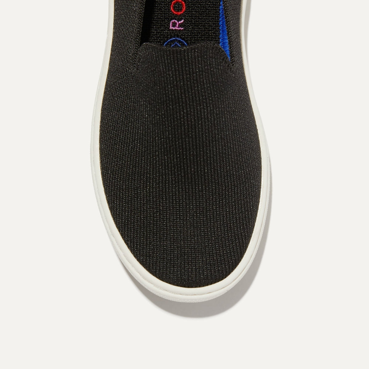 The Kids slip-on Sneaker in Black shown from the top view with detailing of the front of the shoe.