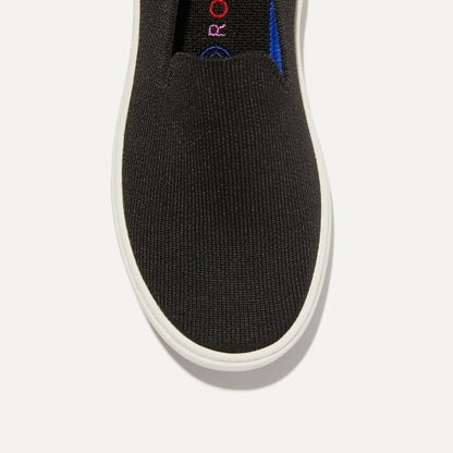 The Kids slip-on Sneaker in Black shown from the top view with detailing of the front of the shoe.