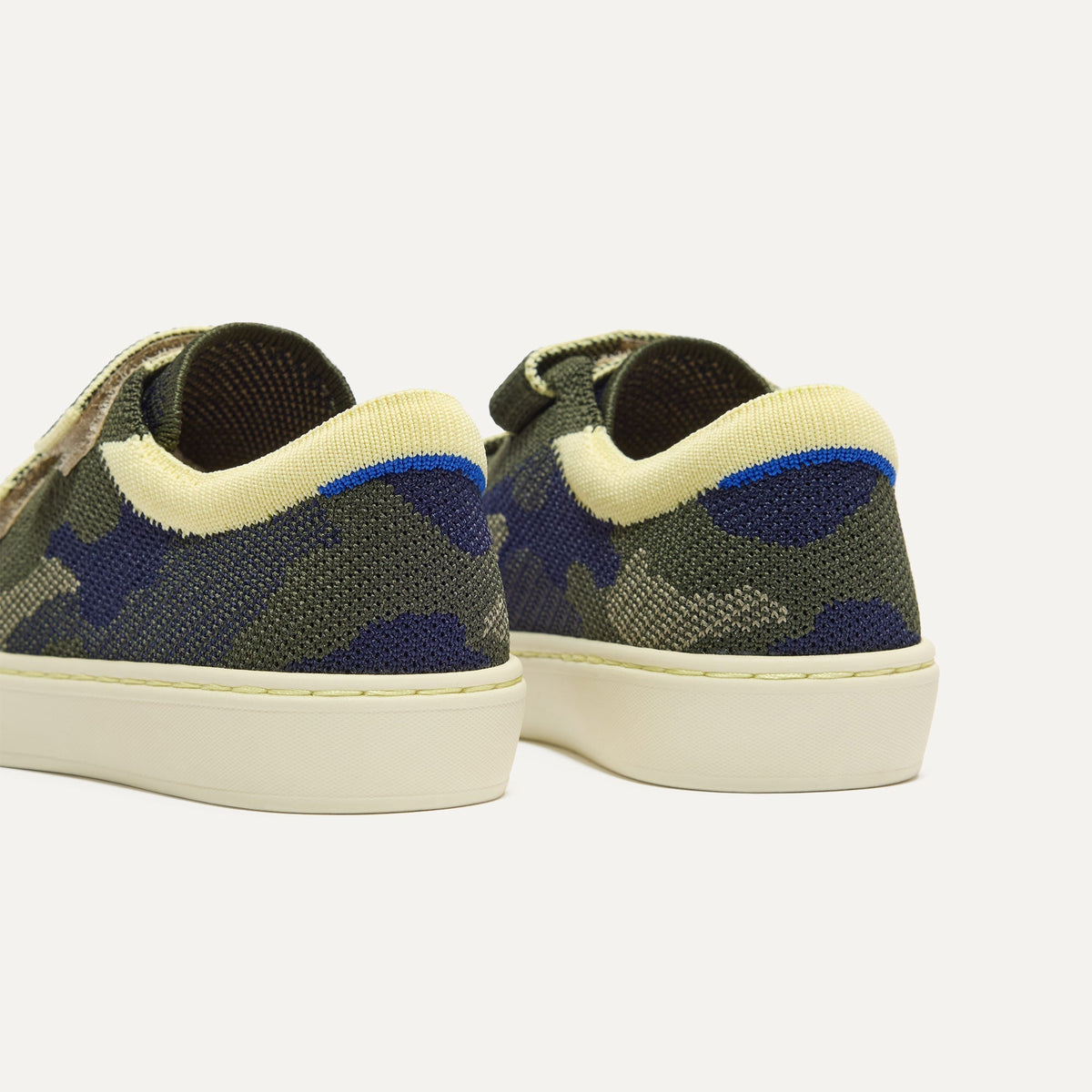 Close up of the heel of The Kids Strap Sneaker in Spruce Camo, with Rothy's signature blue halo.