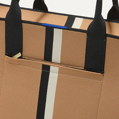 A closeup of The Classic Tote in Grand Piano, focusing on the exterior zip pocket.