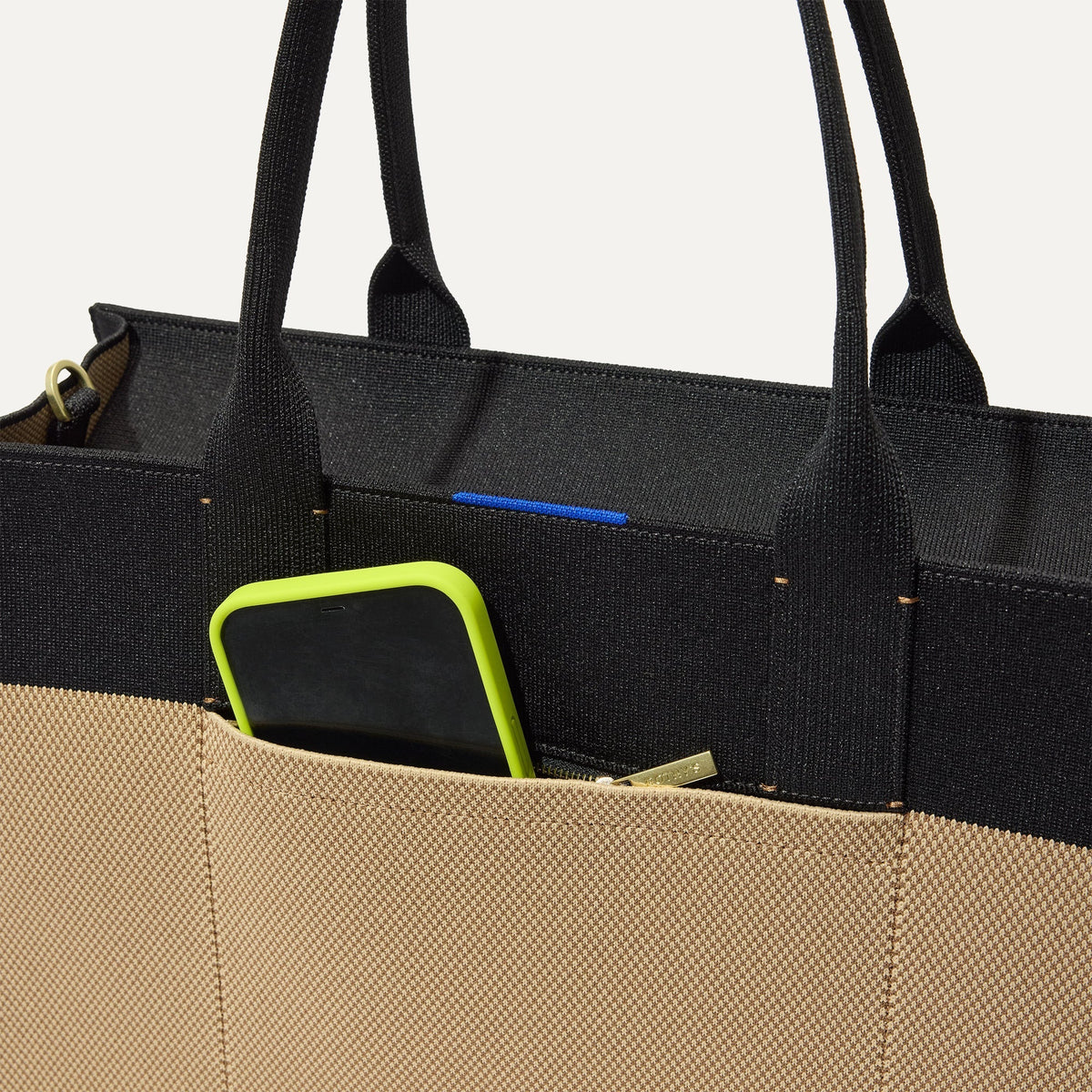 A closeup of The Classic Tote in Tiramisu, focusing on the exterior zip pocket.