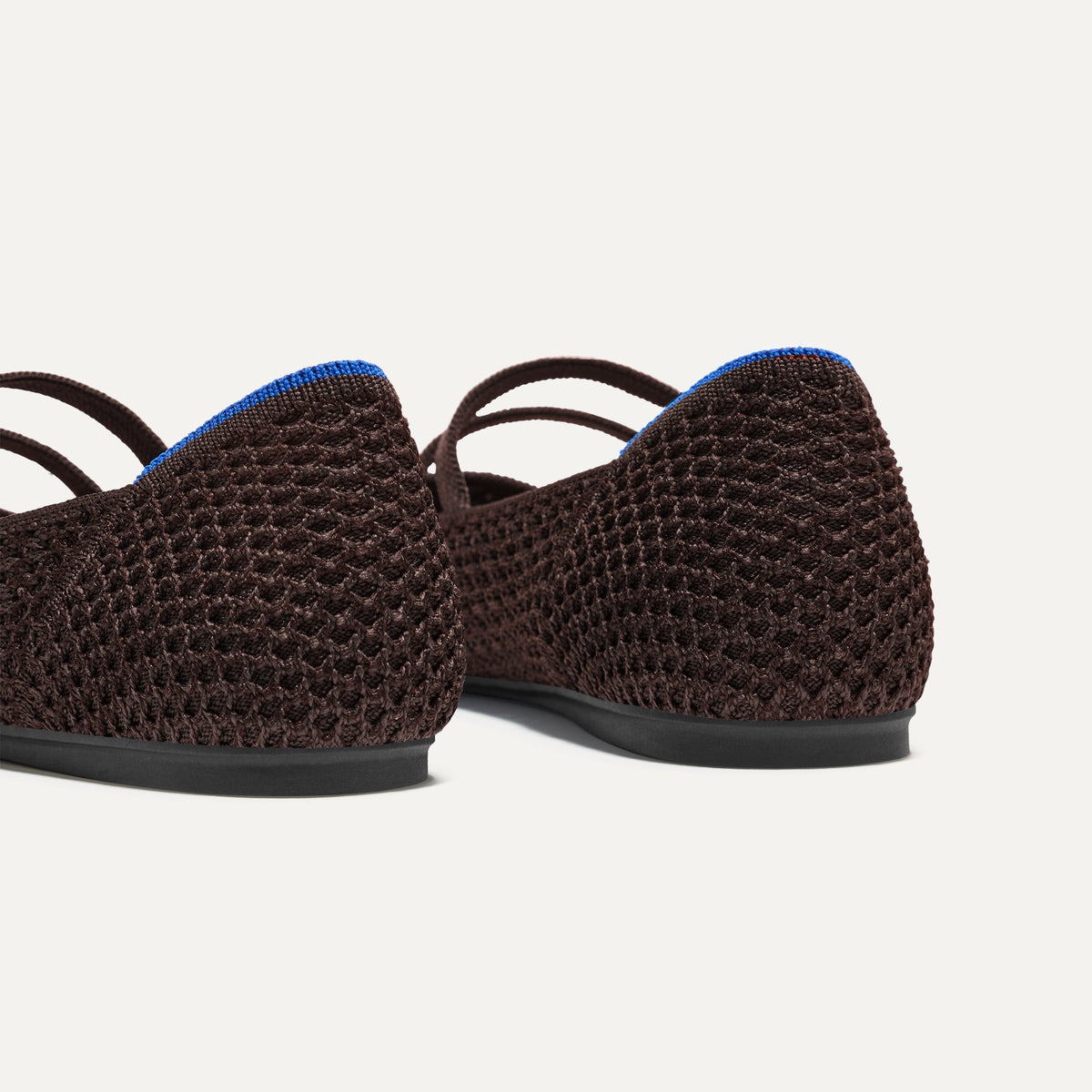 Close up of the heel of The Double Buckle Mary Jane in Chocolate Mesh, with Rothy's signature blue halo.