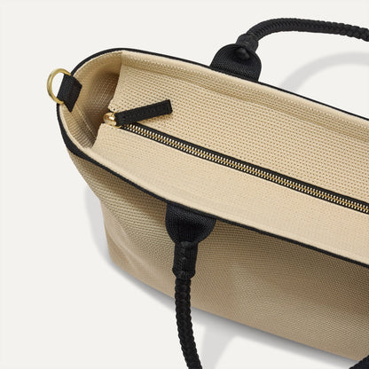 The Lightweight Zip Tote in Black and White Raffia-Knit, focusing on the zip closure and handles.