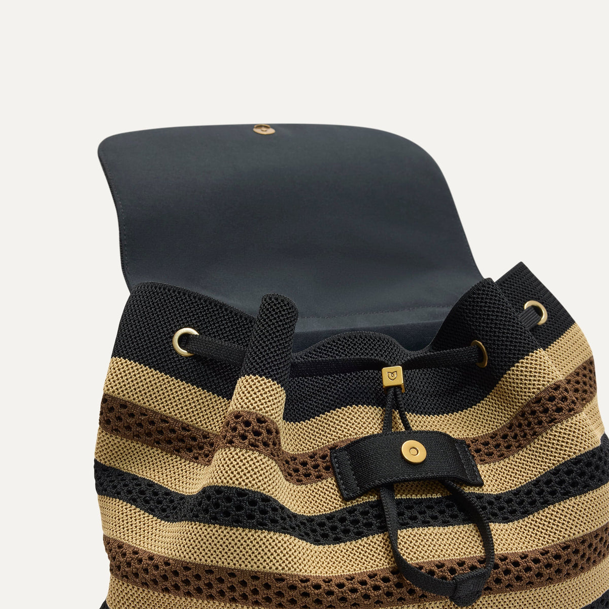 A close up of The Cinch Backpack in Mocha Stripe Crochet showing the drawstring closure.