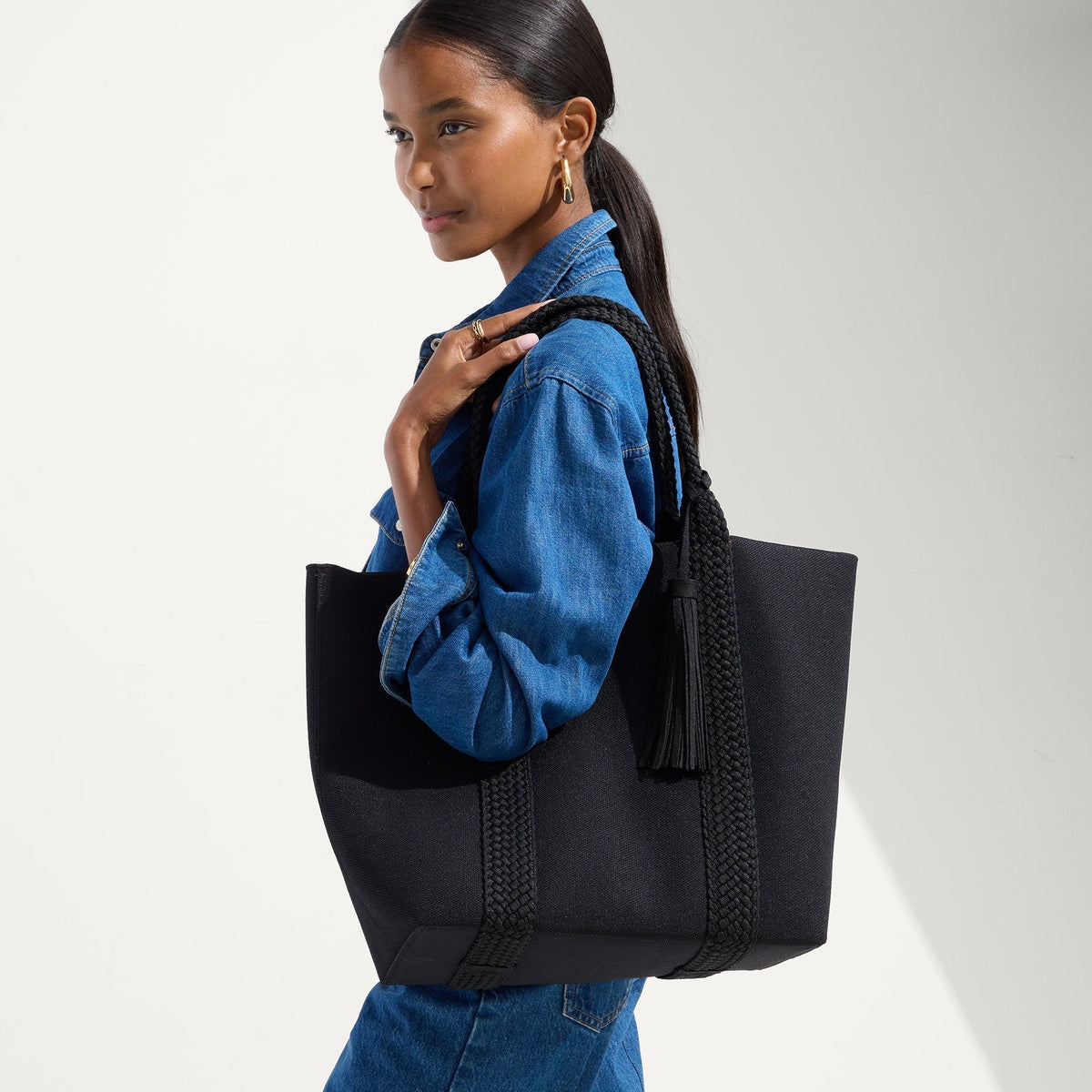 hover | Model holding The Lightweight Tote in Black Licorice.