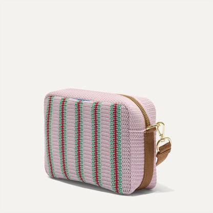 The Crossbody Camera Bag in Watermelon Market Stripe, shown from the side.
