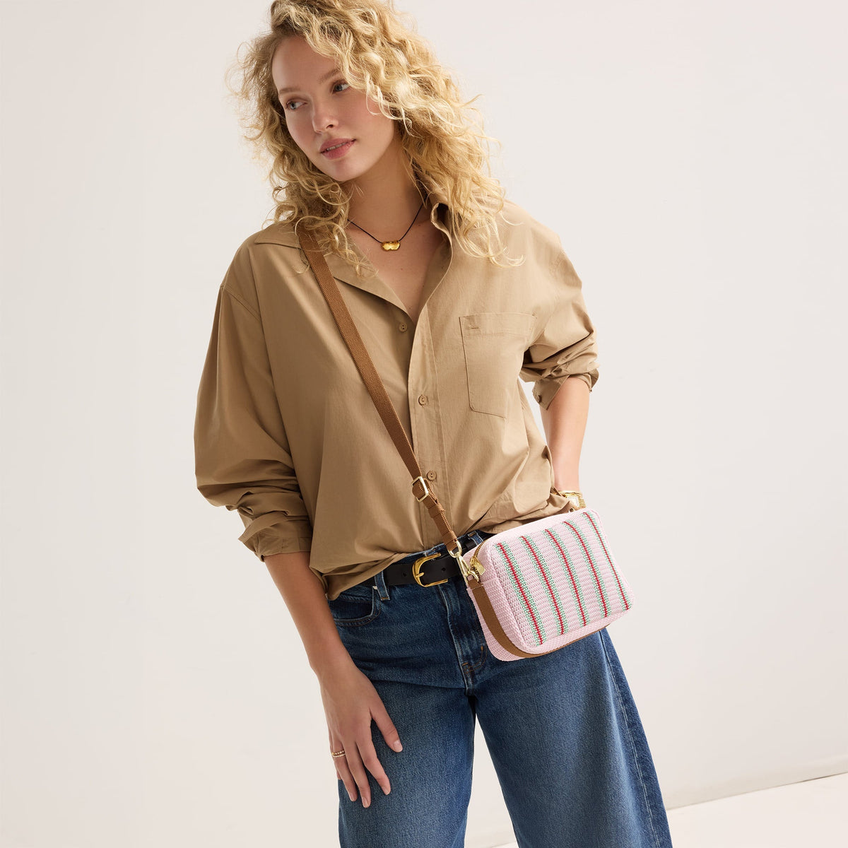 hover | The Crossbody Camera Bag in Watermelon Market Stripe worn as a crossbody by a model.