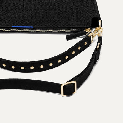 The Daily Crossbody in Revelvet™ Black lying flat, showing the detachable top handle and adjustable crossbody strap.
