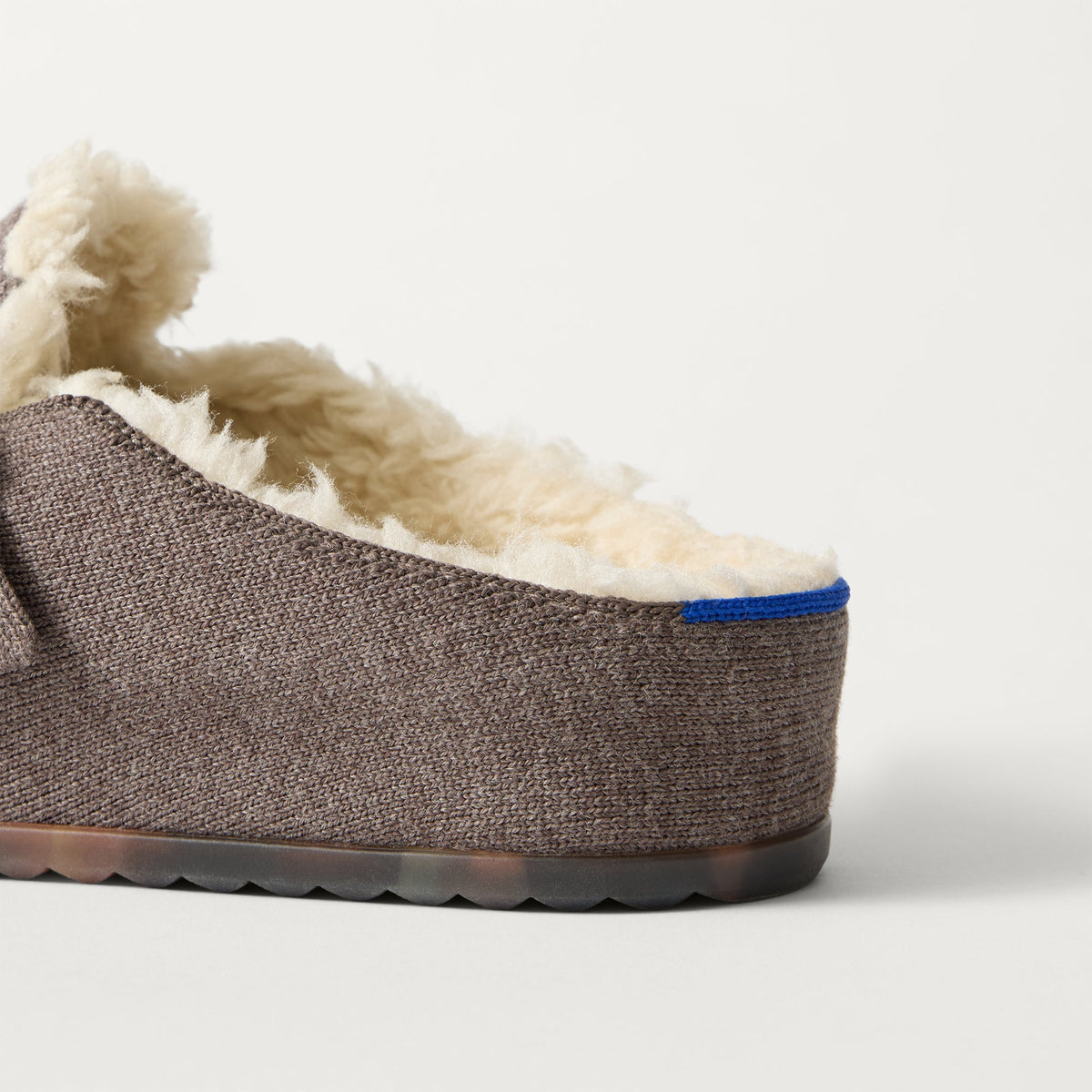 Close up of the heel of The Teddy Buckle Clog in Porcini, with Rothy's signature blue halo.