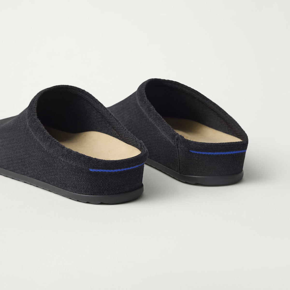 Close up of the heel of The Casual Clog in ReVelvet™ Black, with Rothy's signature blue halo.