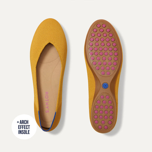 The Daily Flat in Marigold shown from the top with one shoe showing the outsole.