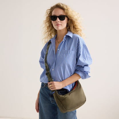 hover |Model carrying The Travel Sling in Forest shown from the front.