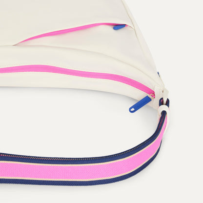 A closeup of The Travel Sling in Optic, showing the smooth zipper closure and soft, flexible handle.