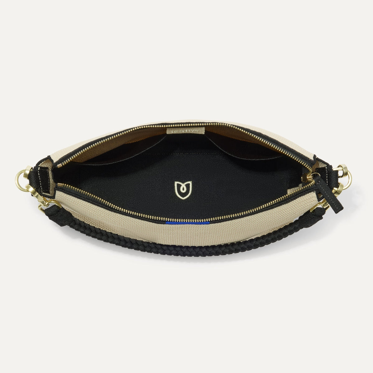 The Daily Crossbody in Black and White Raffia-Knit, shown from the top down, with zipper open and interior exposed.