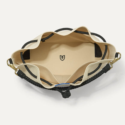 The Cinch Bucket Bag in Black and White Raffia-Knit shown from above with the interior exposed.