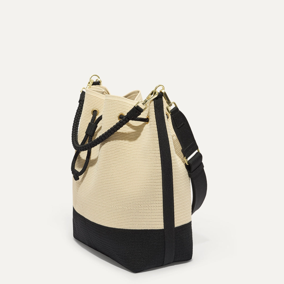 The Cinch Bucket Bag in Black and White Raffia-Knit shown from the side.