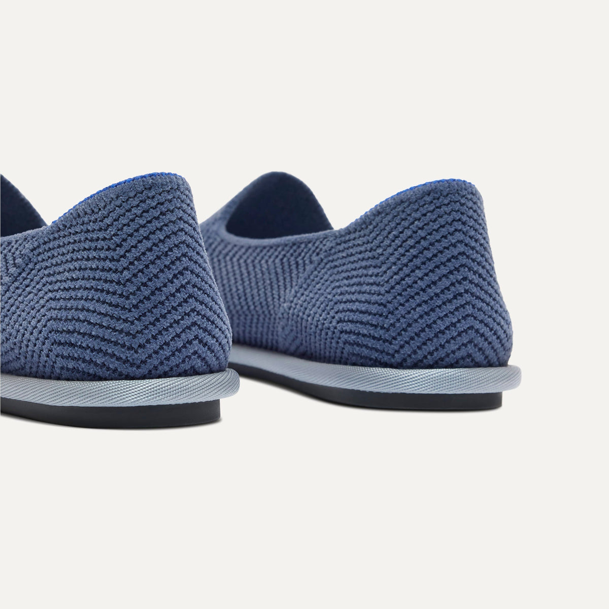Close up of the heel of The Cruiser Loafer in ReVelvet Fog Herringbone, with Rothy's signature blue halo.