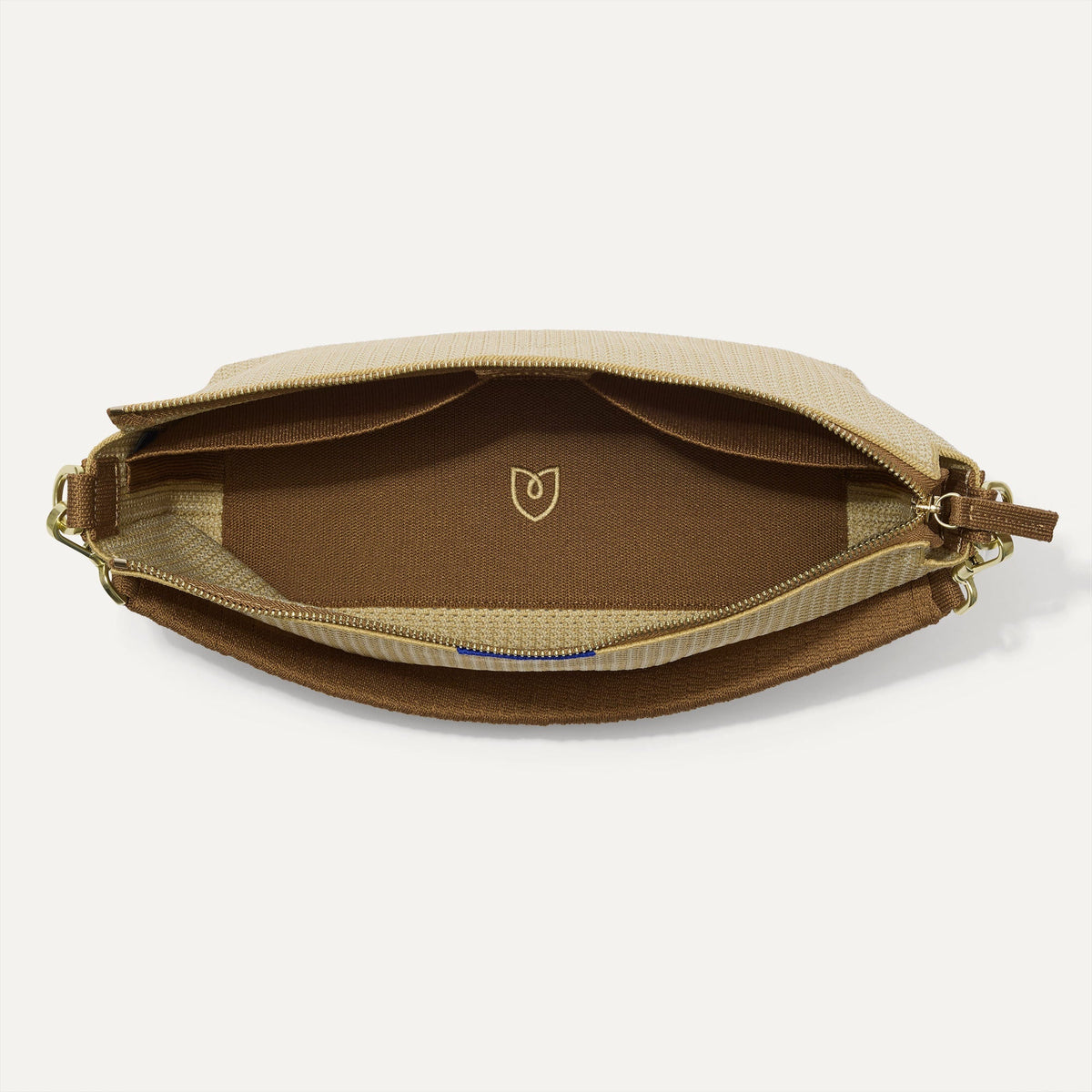 The Daily Crossbody in Macadamia Open-Knit shown from the top down, with zipper open and interior exposed.