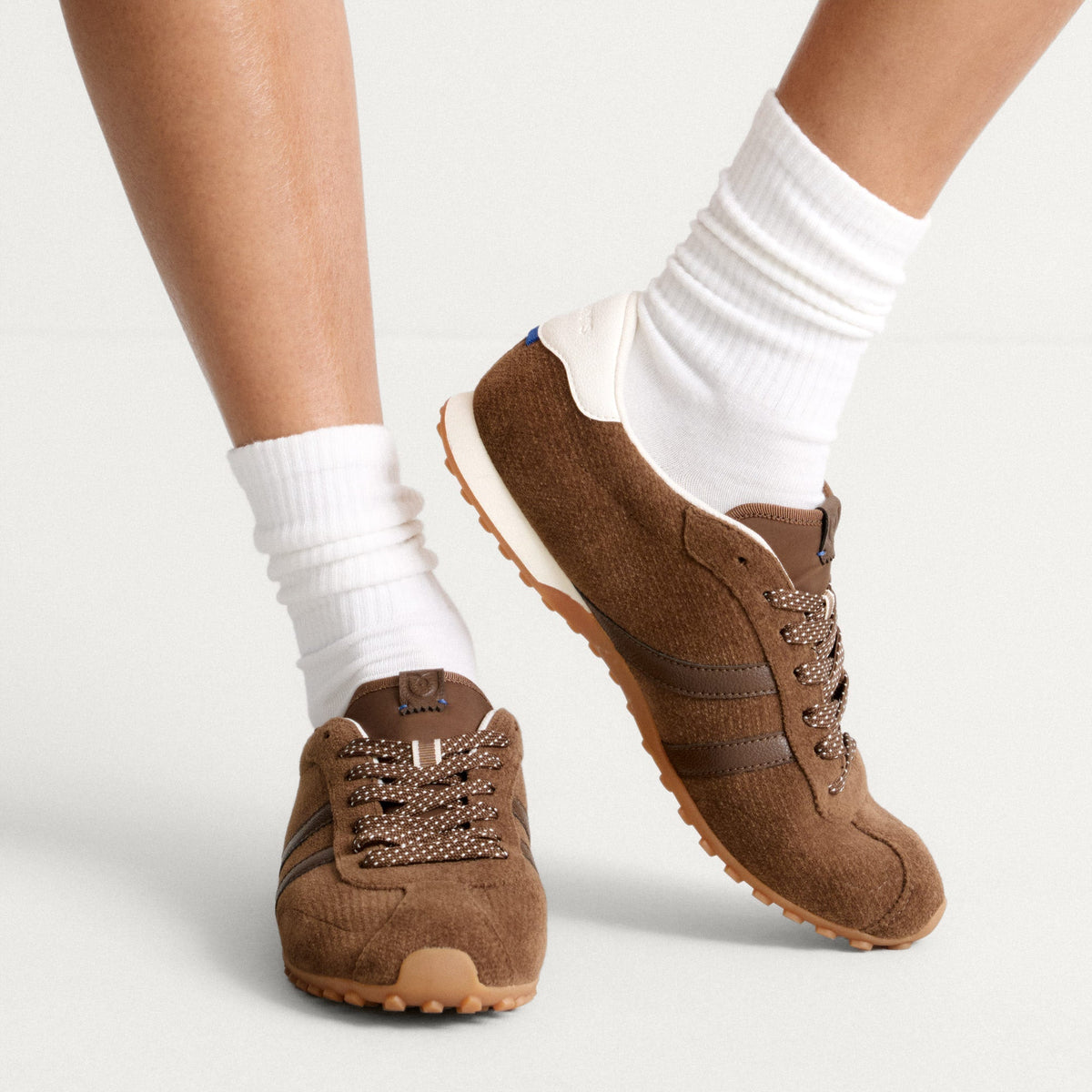 hover | Model wearing The Ivy Sneaker in ReVelvet Cinnamon.