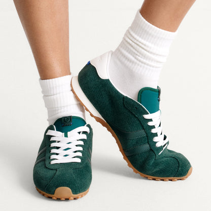 hover | Model wearing The Ivy Sneaker in ReVelvet Evergreen.