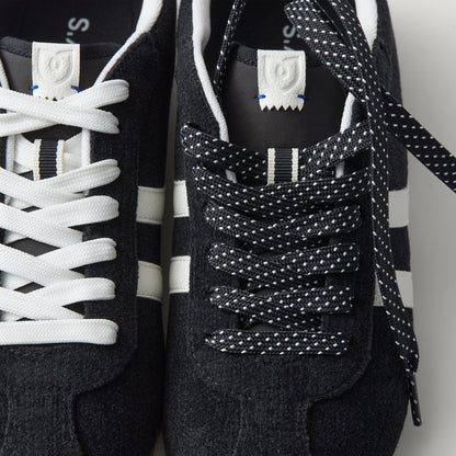 Overlay:: Extra pair of laces included—swap for a new look anytime. | Alt:: Close up of the top of The Ivy Sneaker in ReVelvet Black, showing different lace choices.