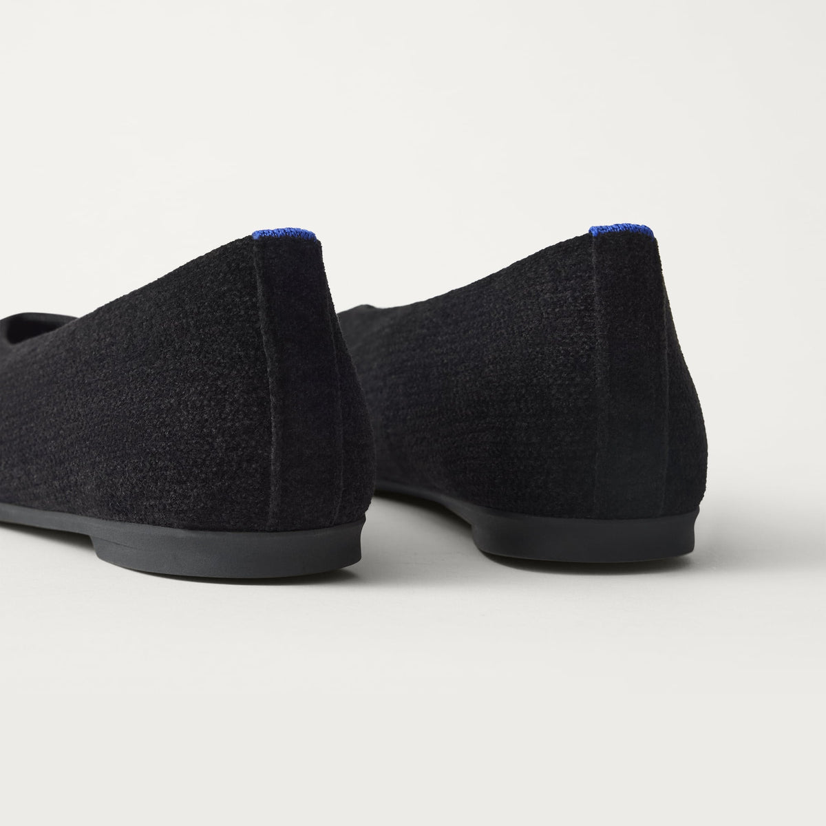 Close up of the heel of The Max Square Ballerina in ReVelvet Black with Rothy's signature blue halo.