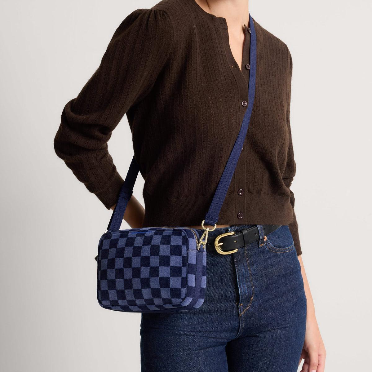 hover | Model wearing The Crossbody Camera Bag in ReVelvet™ Blue Ink, shown from the front.