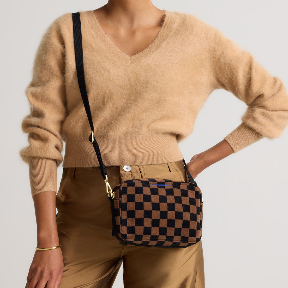 hover | Model wearing The Crossbody Camera Bag in ReVelvet™ Umber Check, shown from the front.